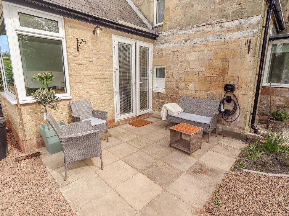 A patio area with chairs and a table at The Lodge in Powburn