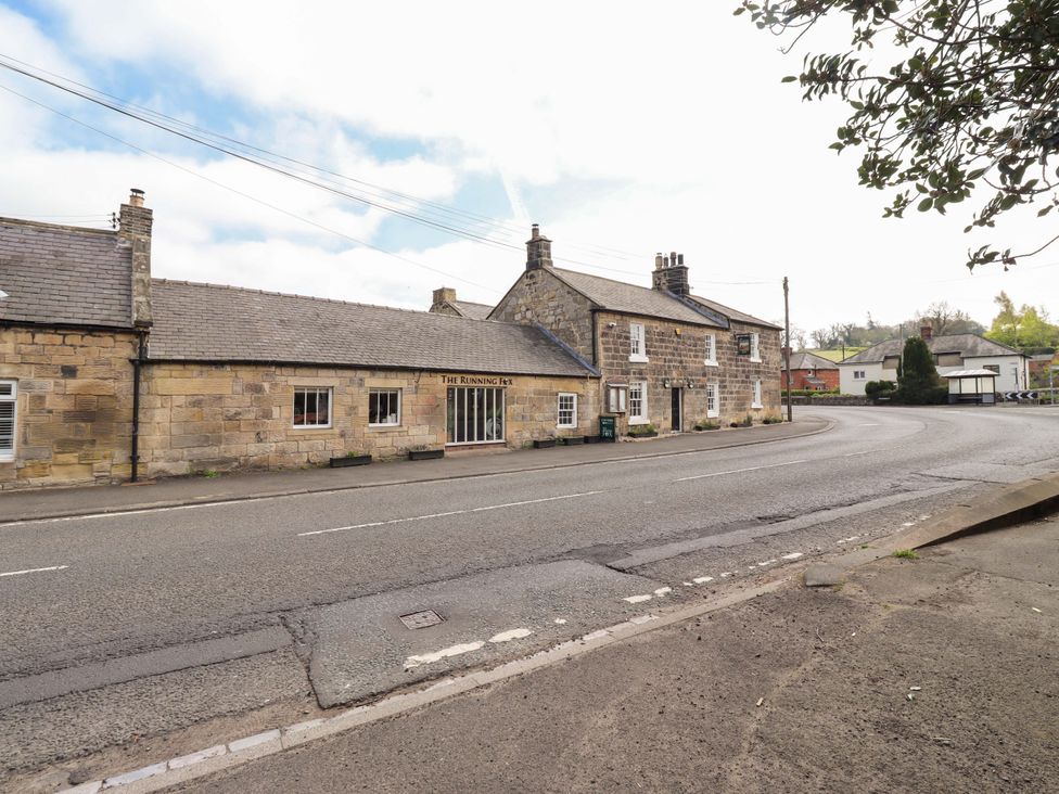 A building on the roadside with signage at The Running Fox in Powburn