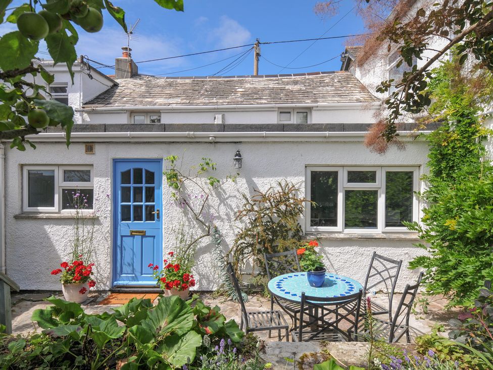A garden with a blue door and a table with chairs at 2 Porthilly Cottages Rock
