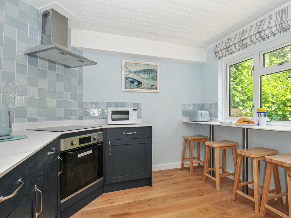 A kitchen with oven and microwave at 2 Porthilly Cottages in Rock