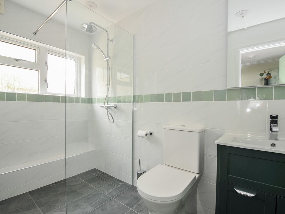 A bathroom with a shower, toilet, and sink at 2 Porthilly Cottages in Rock