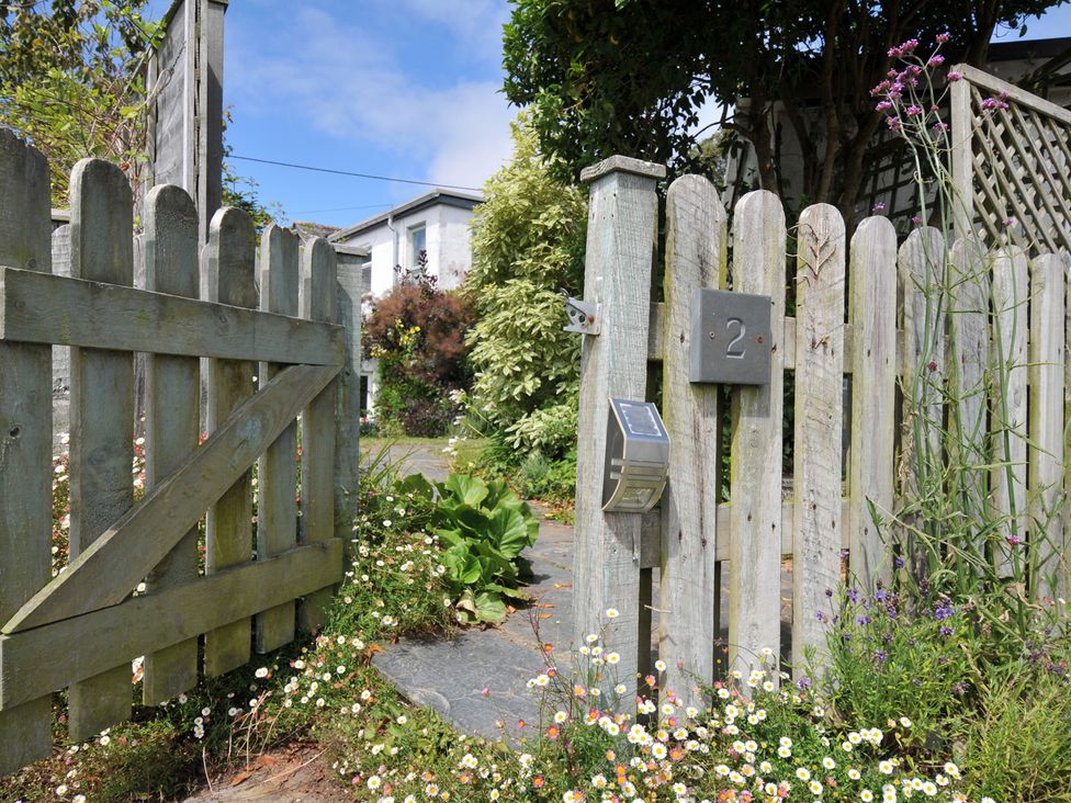 A garden entrance with a gate and floral arrangement at 2 Porthilly Cottages Rock