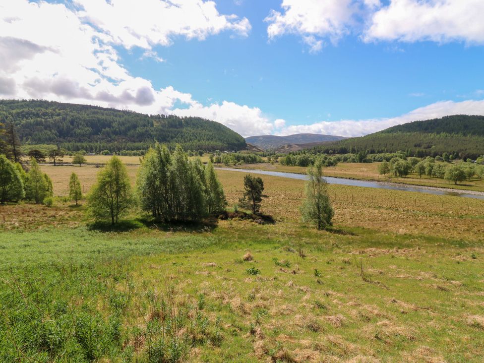 A view of mountains and a river in a green landscape at Creag Bhalg near Mar Lodge