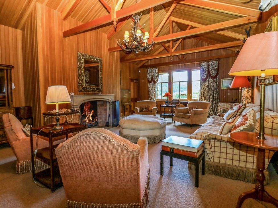 A living room with various seating and a fireplace at Creag Bhalg near Braemar