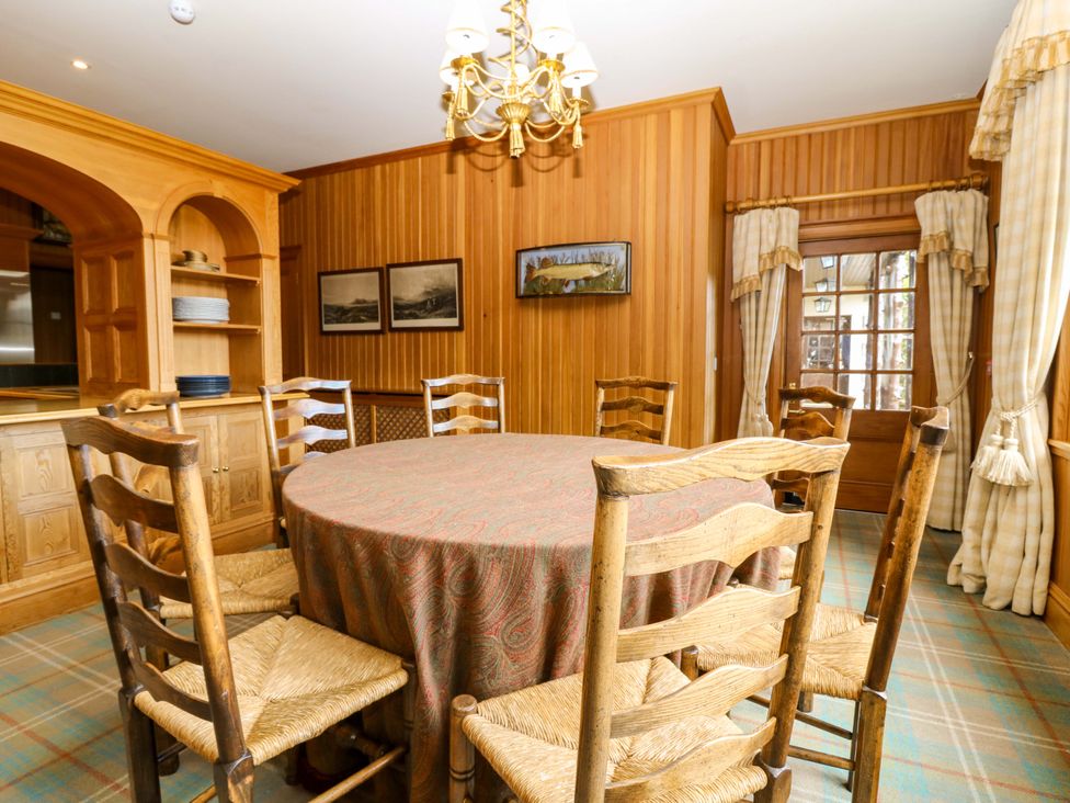 A dining room with a round table and chairs at Creag Bhalg near Mar Lodge near Braemar