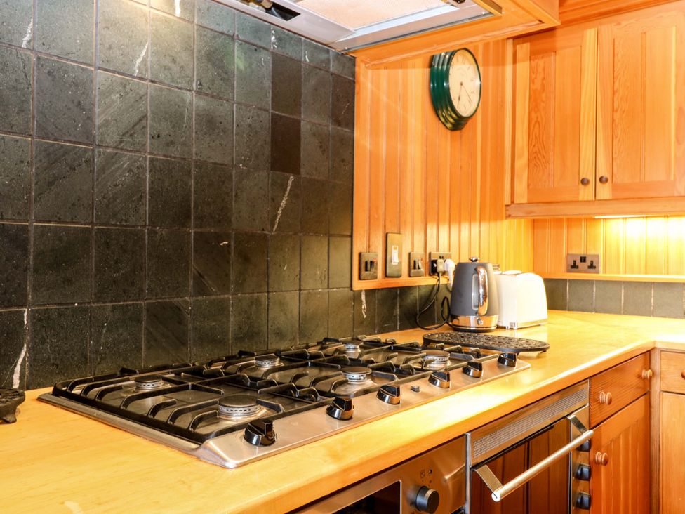 A kitchen with a gas stove and appliances at Creag Bhalg Mar Lodge near Braemar