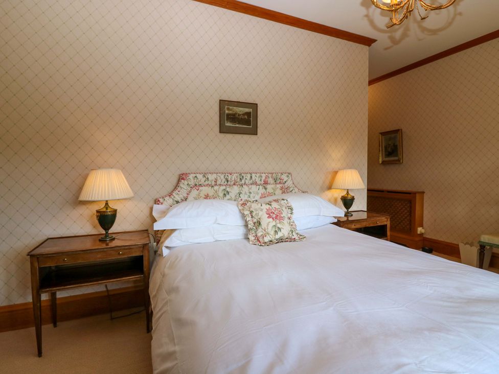 A bedroom with a bed, bedside tables and lamps at Creag Bhalg near Mar Lodge