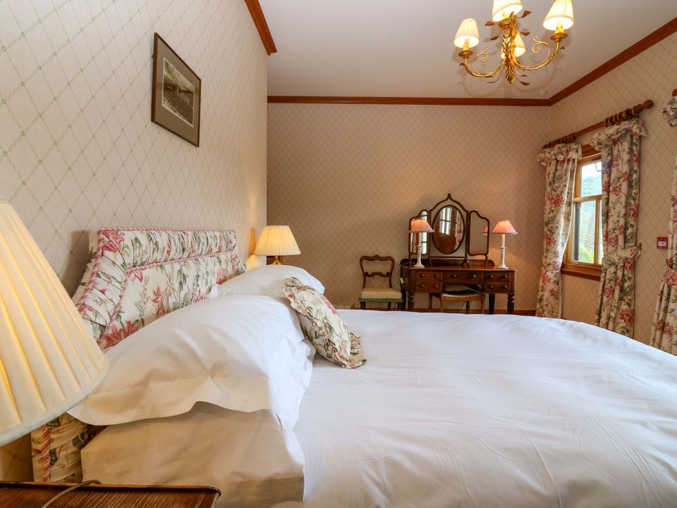 A bedroom with a bed and dressing table at Creag Bhalg near Braemar