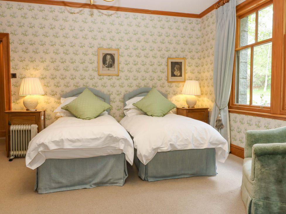 A bedroom with twin beds and a lamp at Creag Bhalg near Mar Lodge Braemar