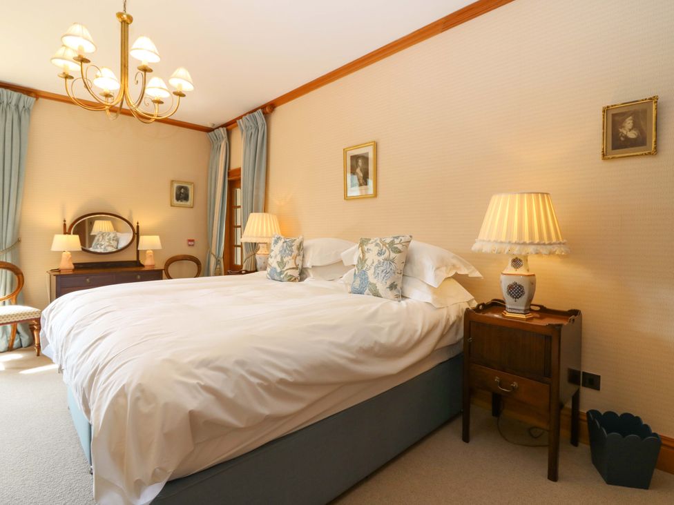 A bedroom with a bed and a nightstand at Creag Bhalg Mar Lodge near Braemar