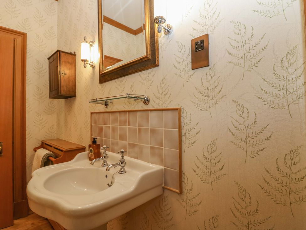 A bathroom with a sink, mirror, and wall cabinet at Creag Bhalg near Mar Lodge near Braemar