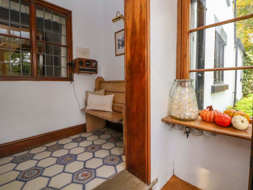 An entrance with a bench and pumpkins on a window ledge at Mickle Trafford Manor in Chester