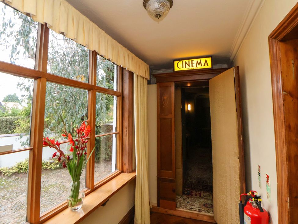 A hallway with a cinema sign and flowers at Mickle Trafford Manor Chester