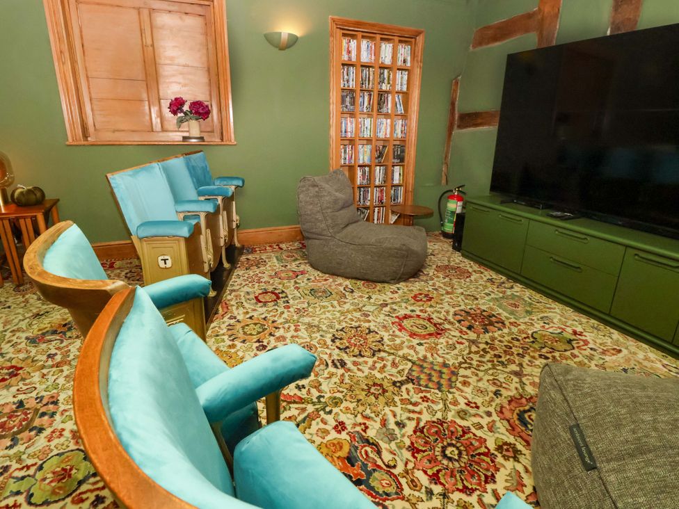 A snug with armchairs and a television at Mickle Trafford Manor in Chester