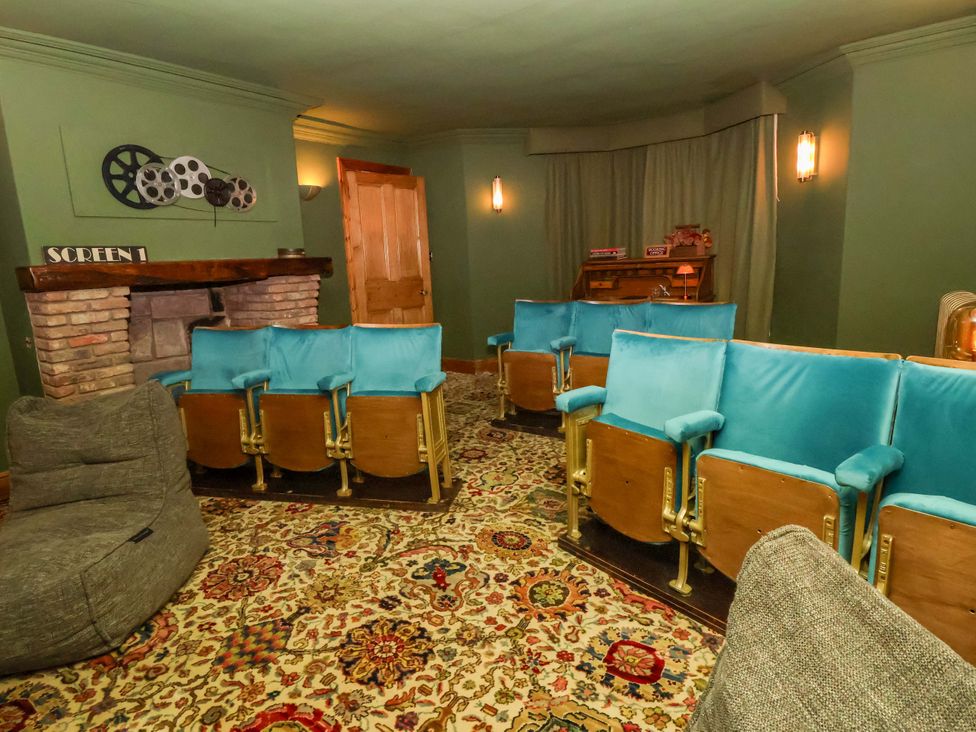 A home theater with theater seats and a fireplace at Mickle Trafford Manor, Chester