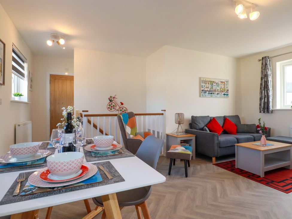 A living room and dining area with bowls and a sofa at 1 Vetch Avenue St Austell