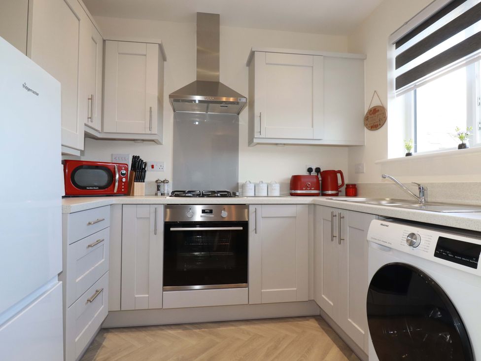 A kitchen with appliances and cabinets at 1 Vetch Avenue, St Austell