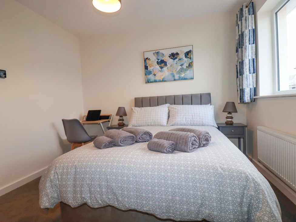 A bedroom with a bed and desk at 1 Vetch Avenue in St Austell