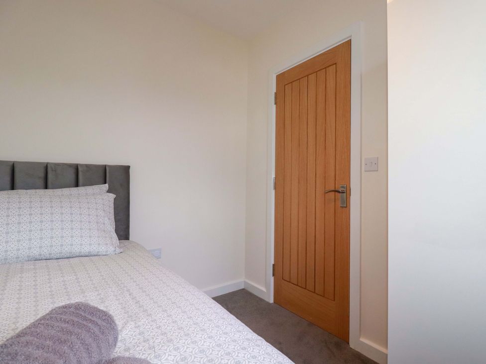 A bedroom with a bed and a door at 1 Vetch Avenue St Austell