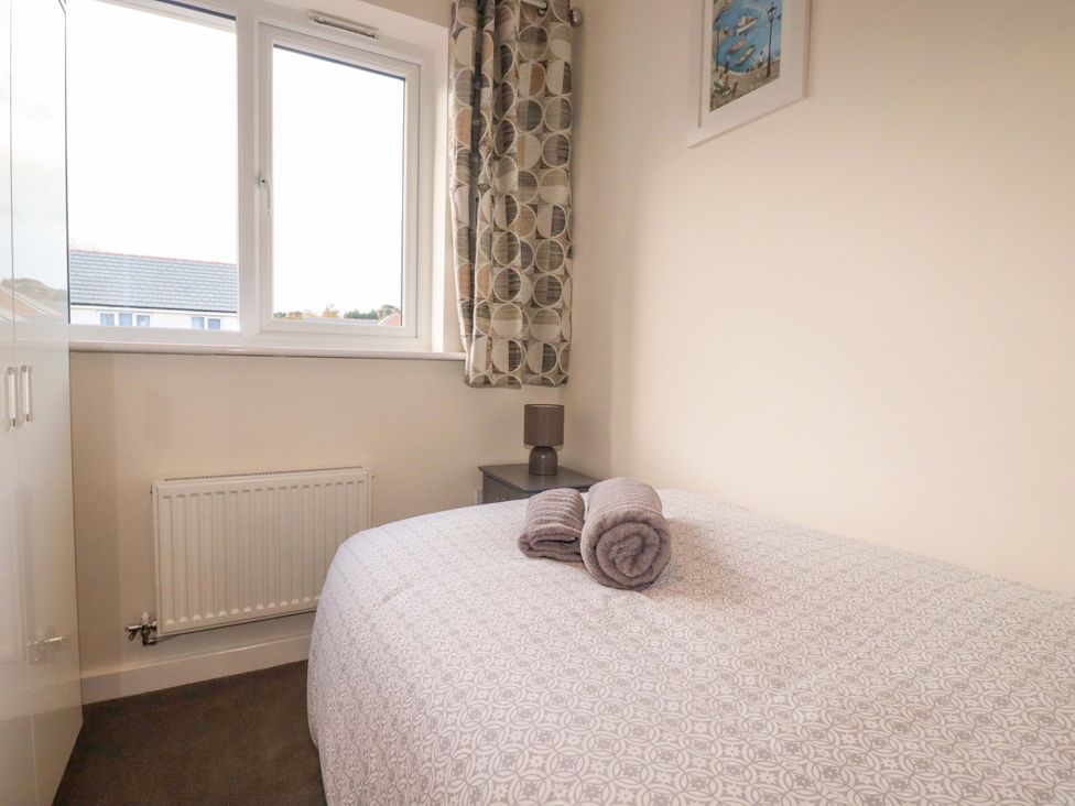 A bedroom with a bed and towels on it at 1 Vetch Avenue in St Austell