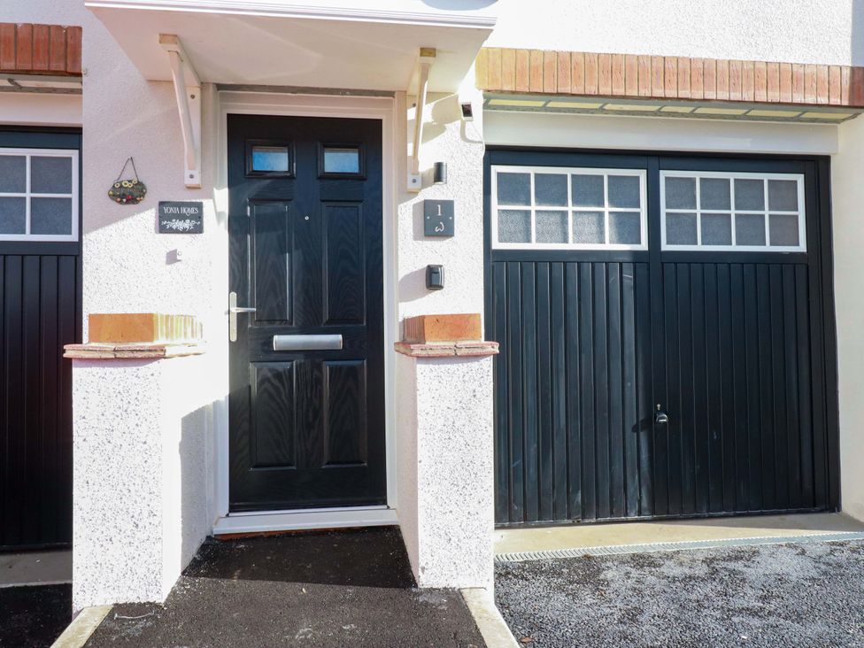 An entrance with a front door and garage door at 1 Vetch Avenue St Austell