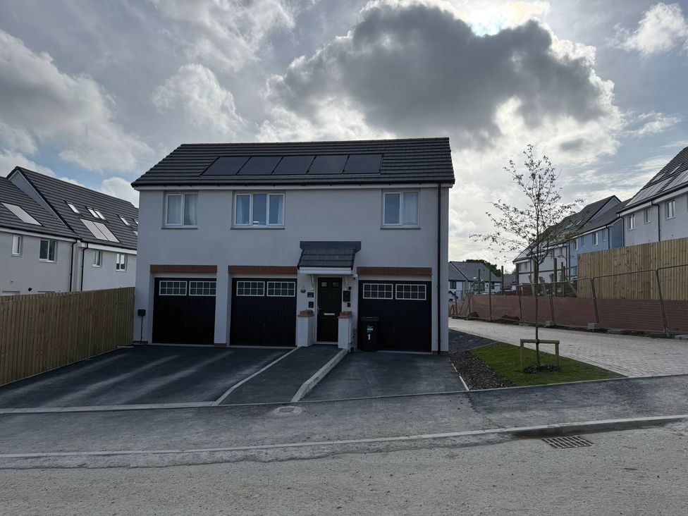 A house with garages and solar panels at Yonja Homes in St Austell