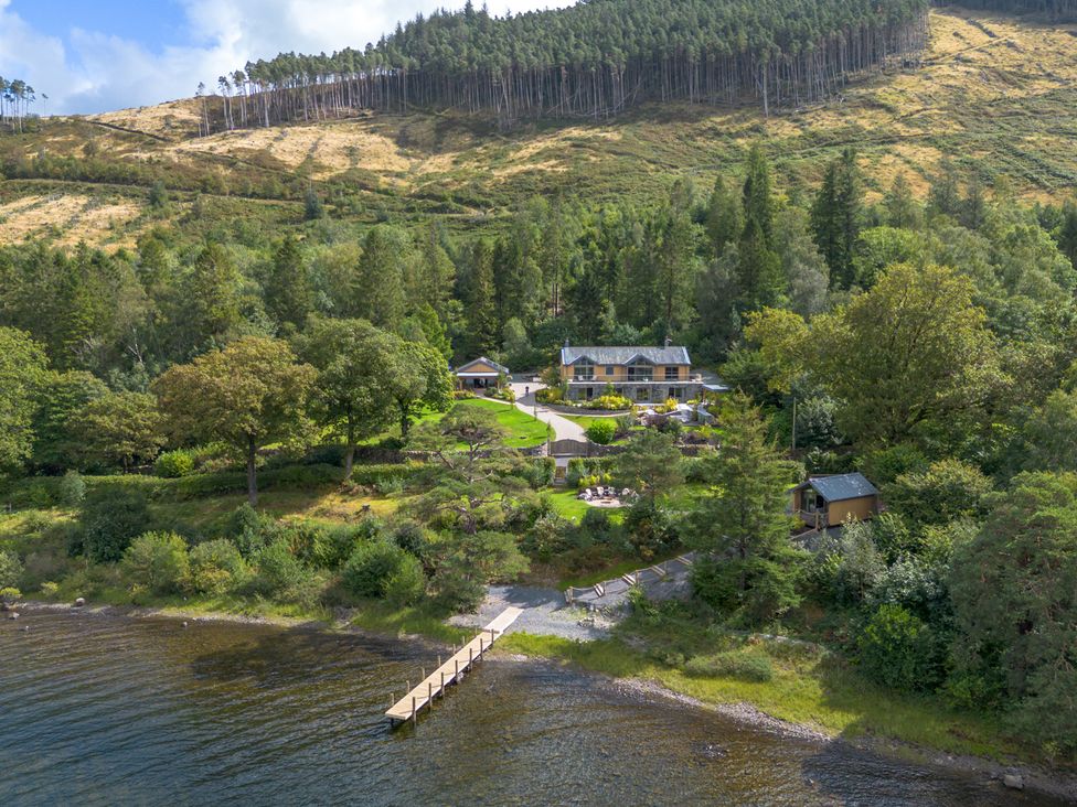 An outdoor area with a house, dock, and garden at Deer Close Coniston