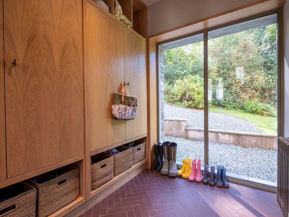An entryway with storage cabinet and rain boots at Deer Close in Coniston