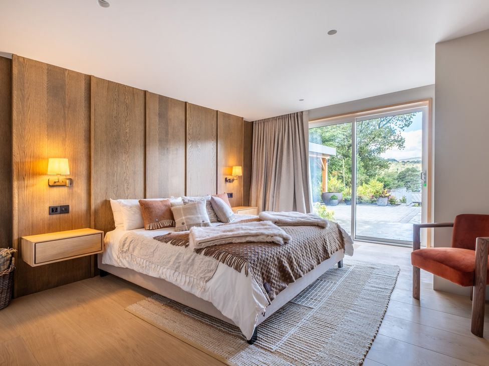 A bedroom with a bed and a sliding door at Deer Close in Coniston