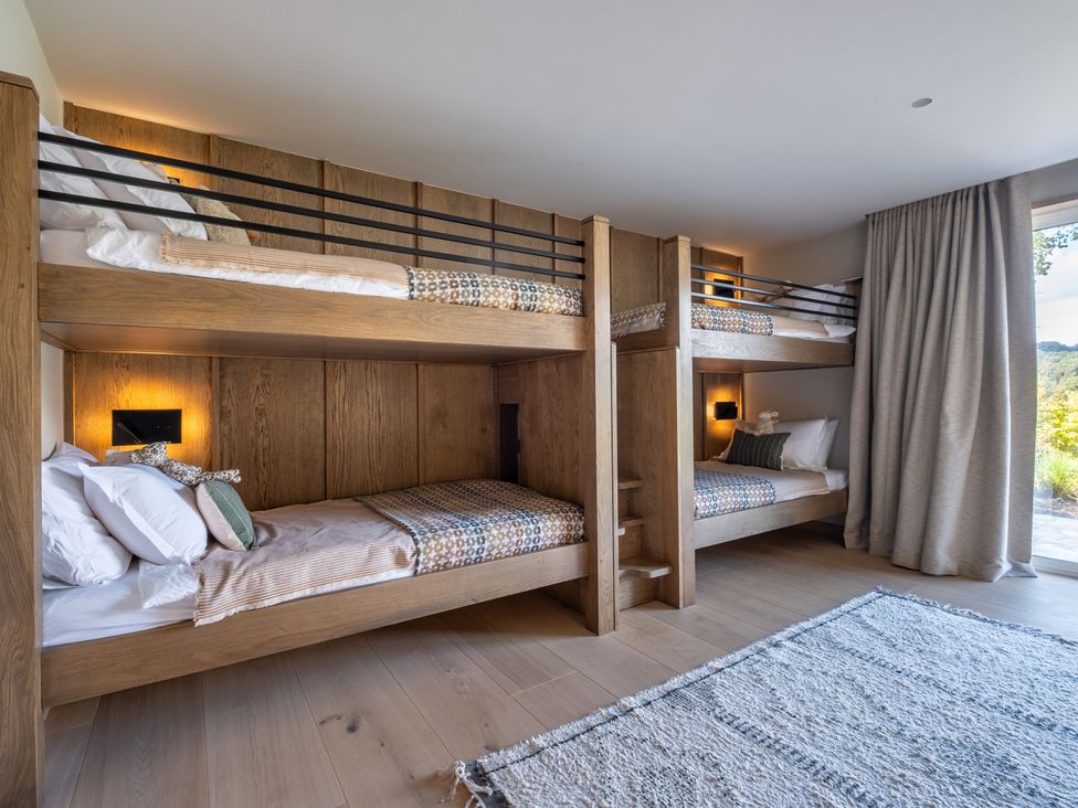 A bedroom with bunk beds and a large window at Deer Close in Coniston