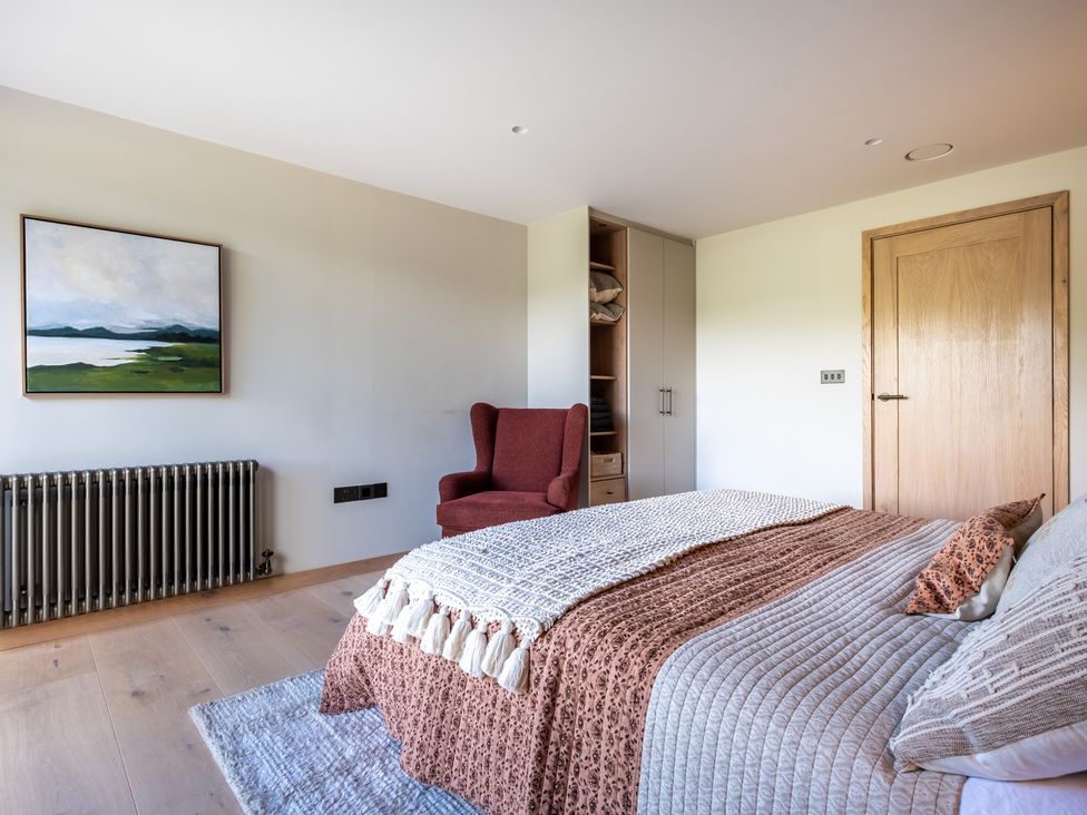 A bedroom with a bed and chair at Deer Close in Coniston