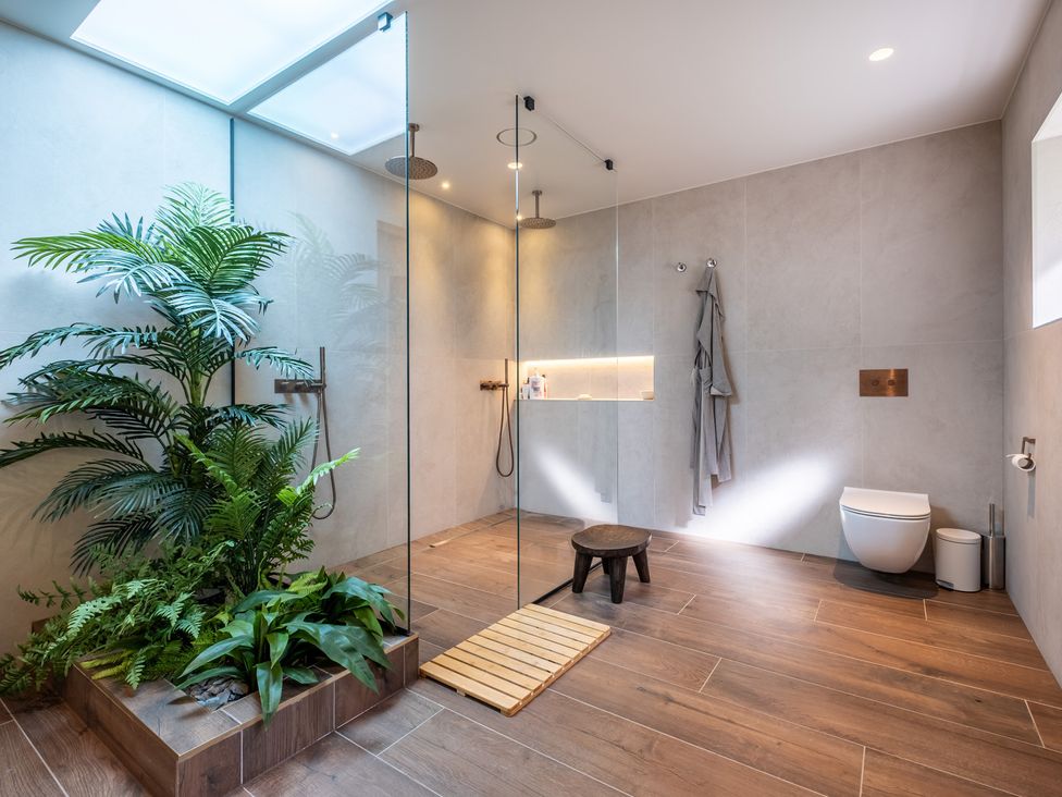 A bathroom with a glass shower and plants at Deer Close in Coniston