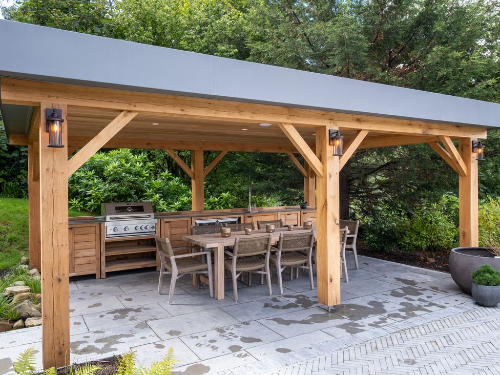 An outdoor kitchen with grill and dining table at Deer Close in Coniston