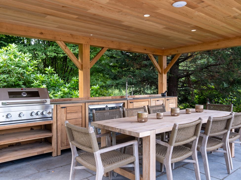 An outdoor kitchen with a grill and dining area at Deer Close in Coniston