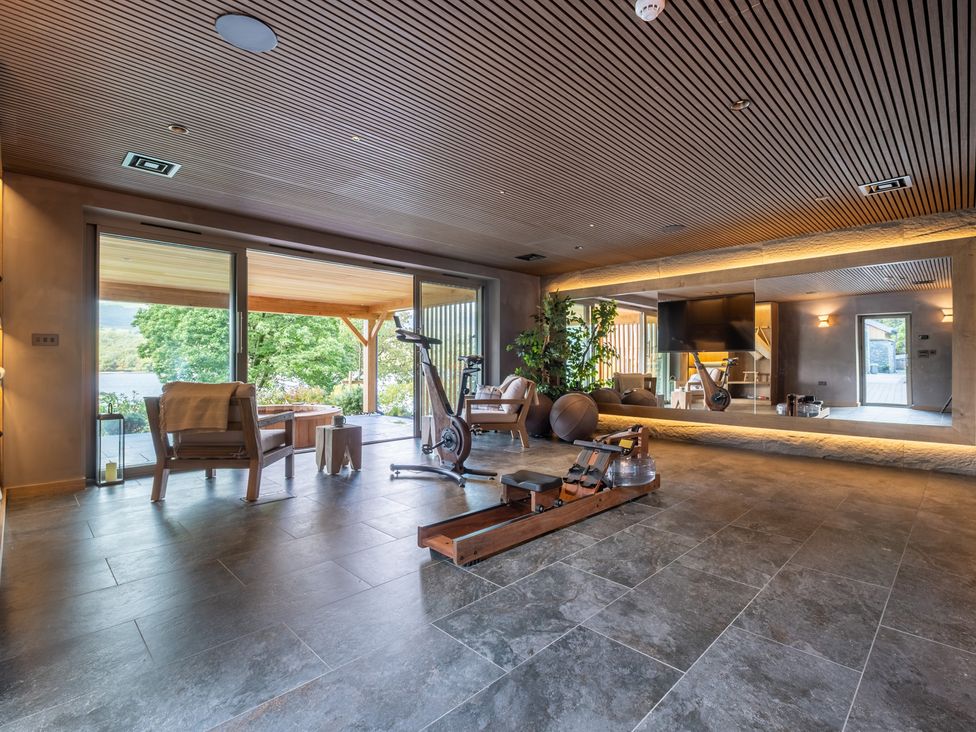 A living room with exercise equipment and furniture at Deer Close in Coniston