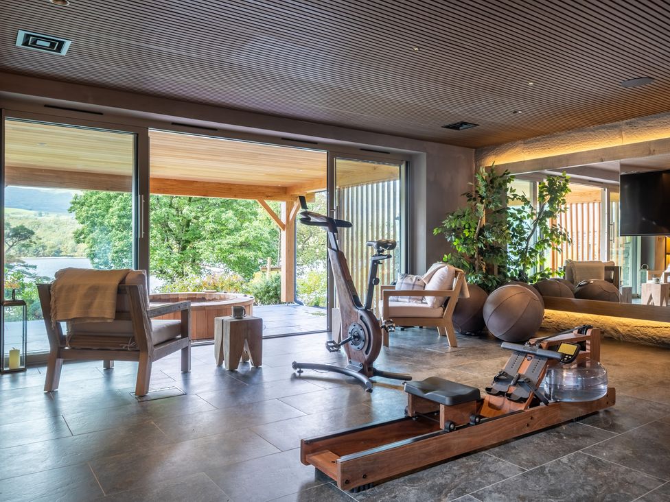 A gym with exercise equipment and large glass doors at Deer Close in Coniston