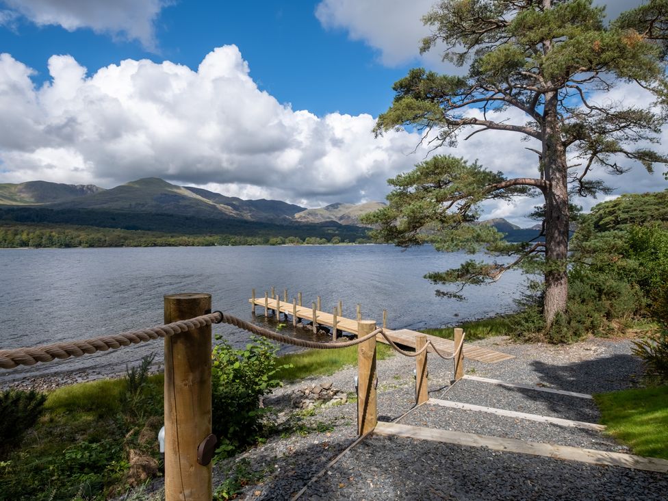 A lake with a dock and steps leading down at Deer Close in Coniston