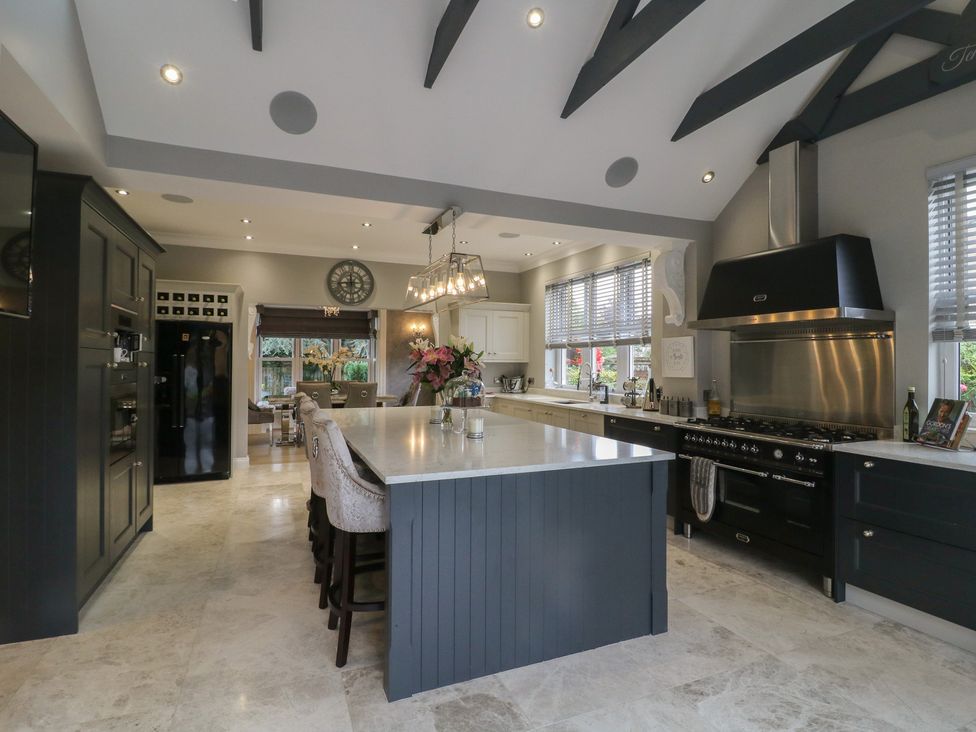 A kitchen with an island and stools at Ten Gables in Driffield