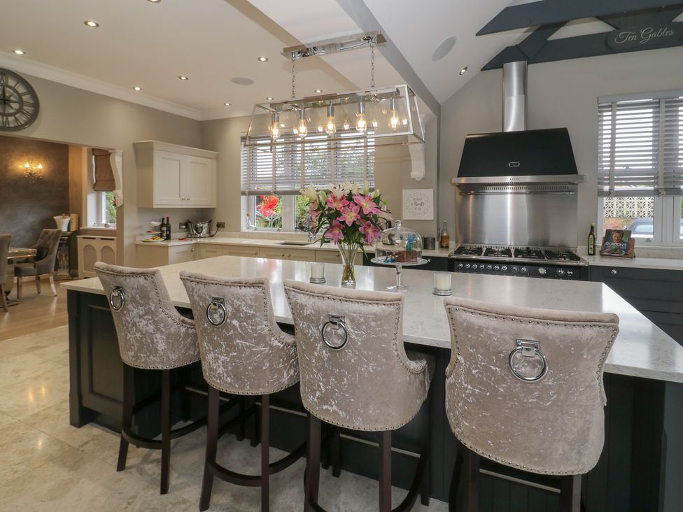 A kitchen with an island and bar stools at Ten Gables in Driffield