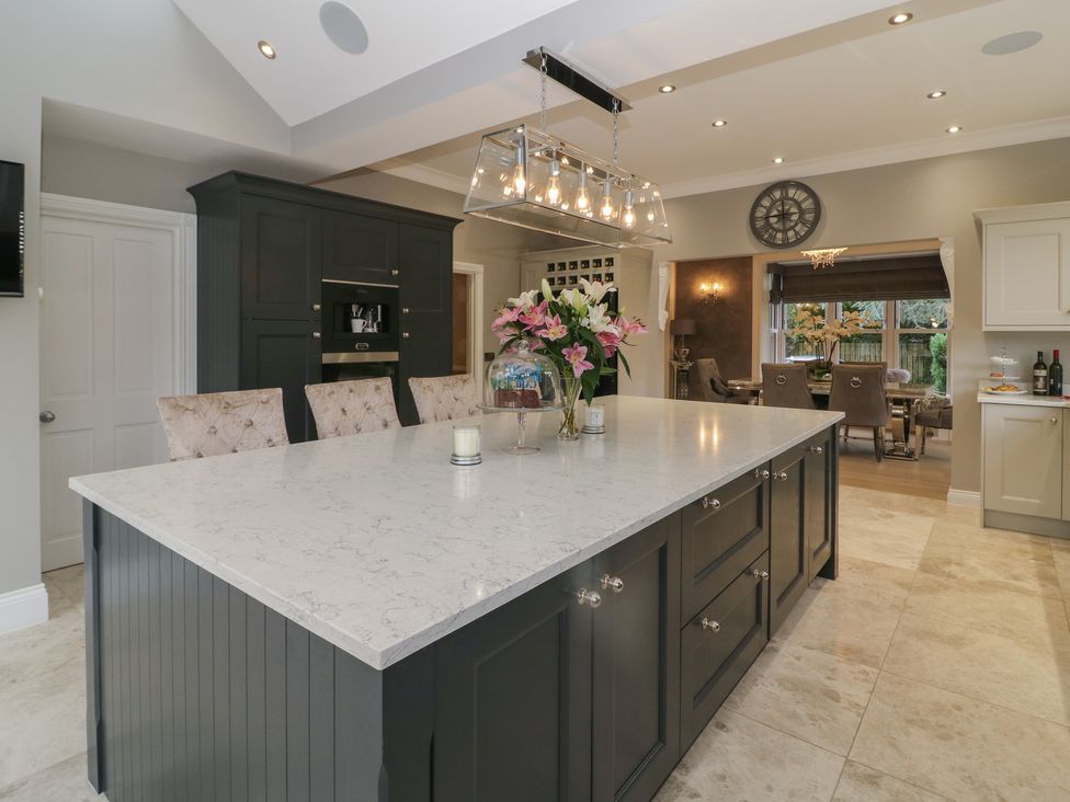 A kitchen with a large island and floral arrangement at Ten Gables in Driffield