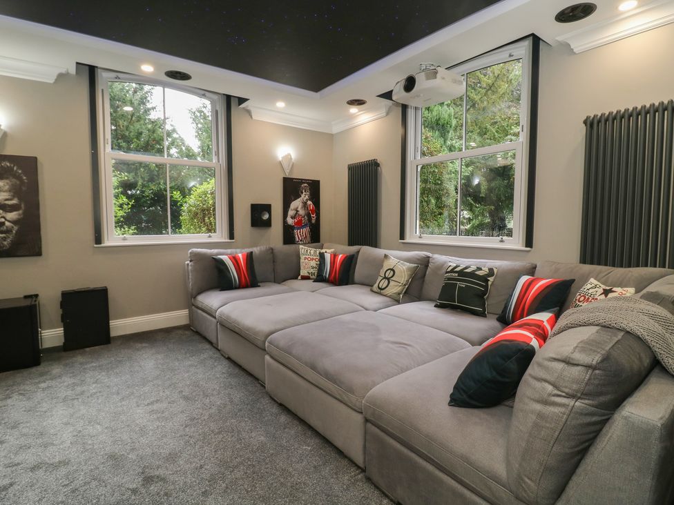 A living room with a large sofa and projector at Ten Gables in Driffield