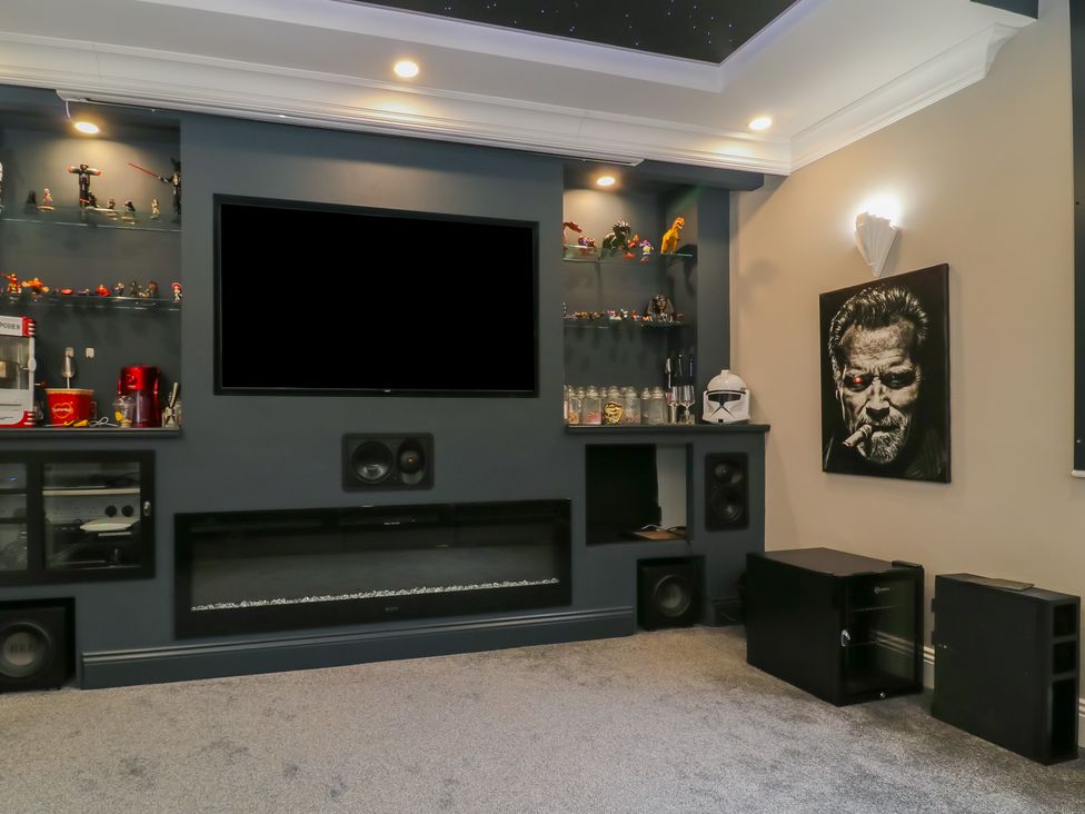 A living room with a television and display shelf at Ten Gables in Driffield