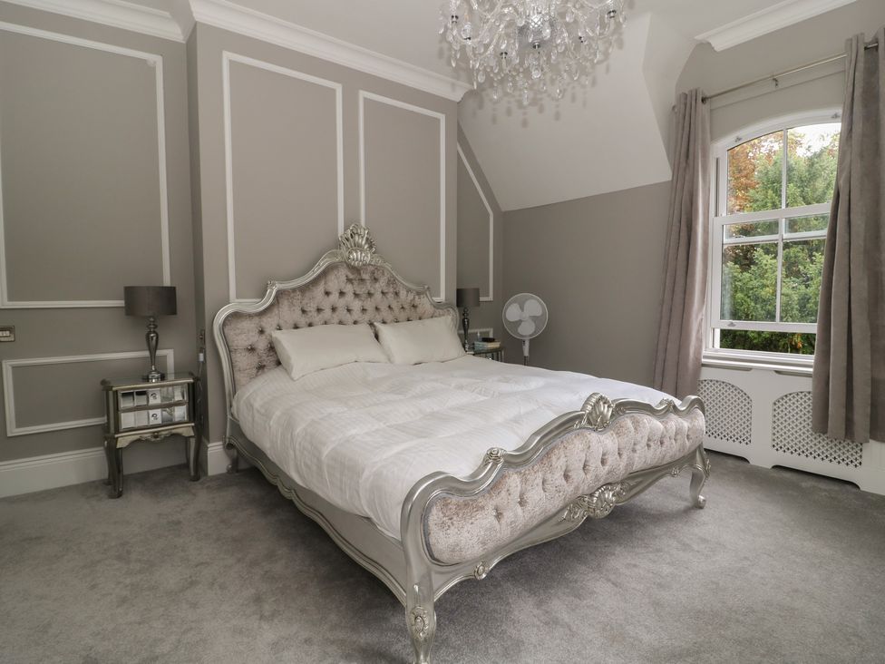 A bedroom with a bed and nightstand at Ten Gables in Driffield