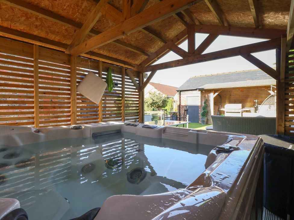 A hot tub in a wooden structure in the garden at Ten Gables in Driffield