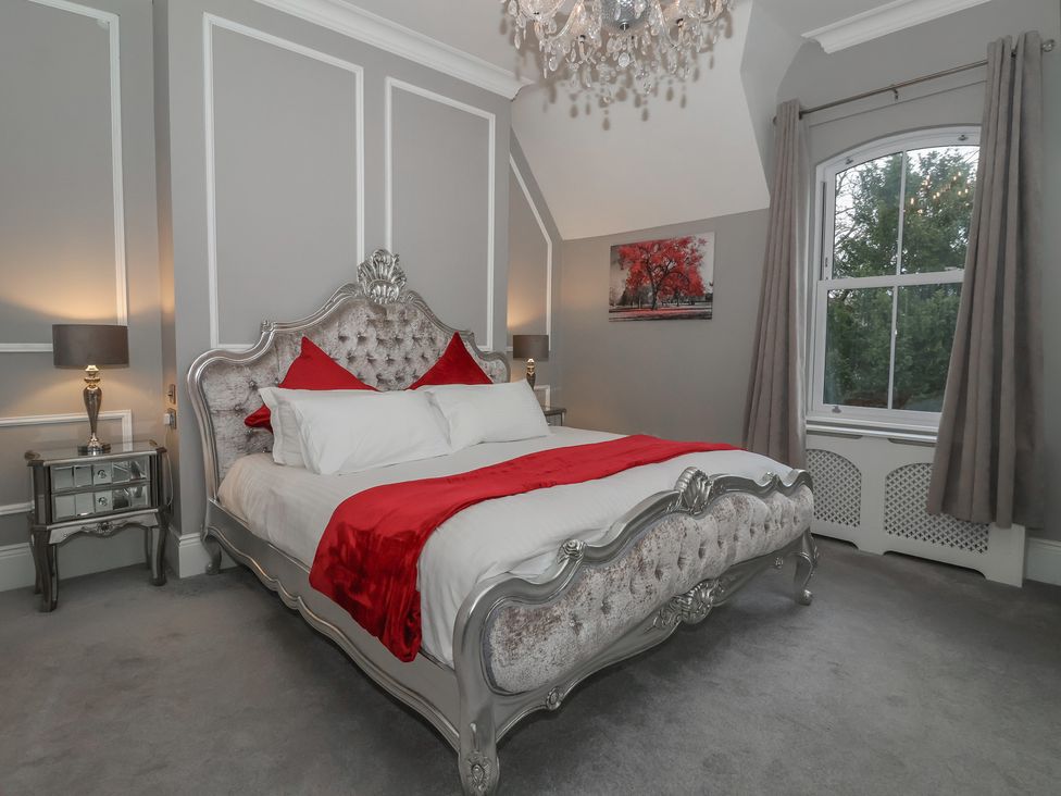 A bedroom with a bed and bedside lamps at Ten Gables Driffield