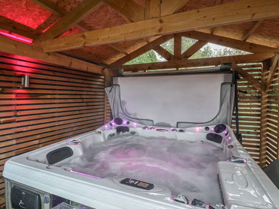 A hot tub with lights in a wooden structure at Ten Gables Driffield