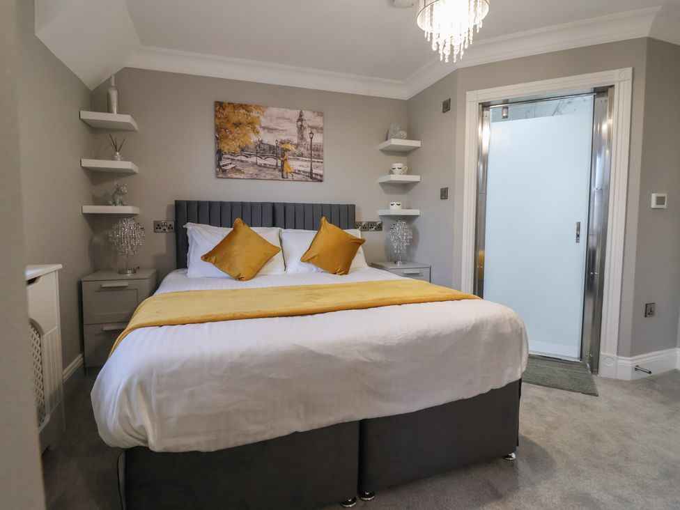 A bedroom with a bed and painting at Ten Gables in Driffield