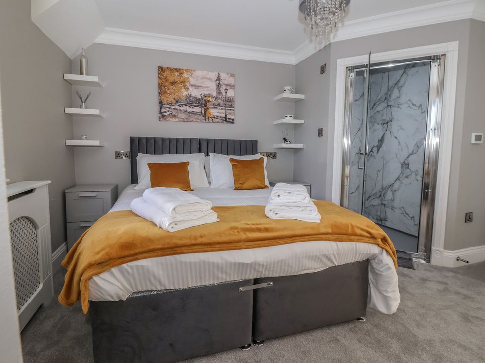 A bedroom with a bed and towels at Ten Gables in Driffield