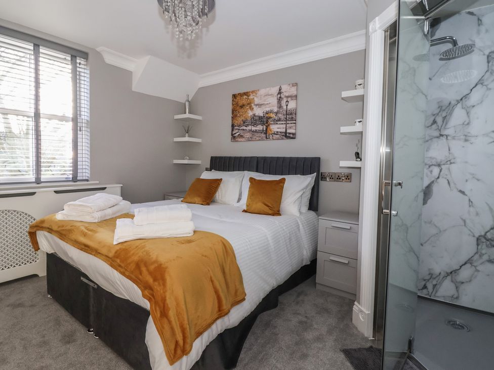 A bedroom with a bed and shower at Ten Gables in Driffield