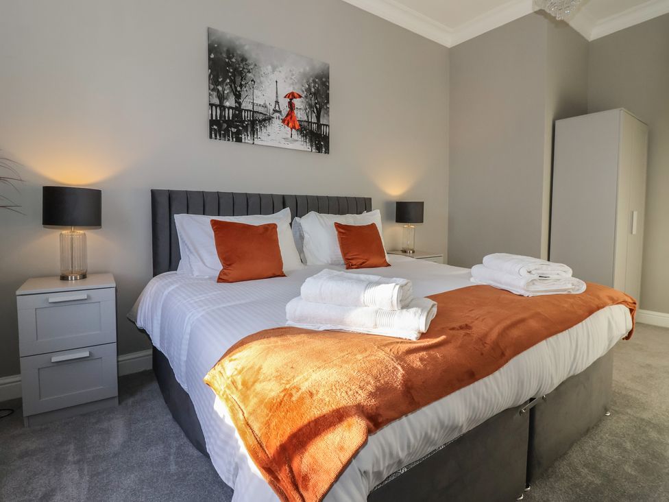 A bedroom with a bed and wall art at Ten Gables in Driffield
